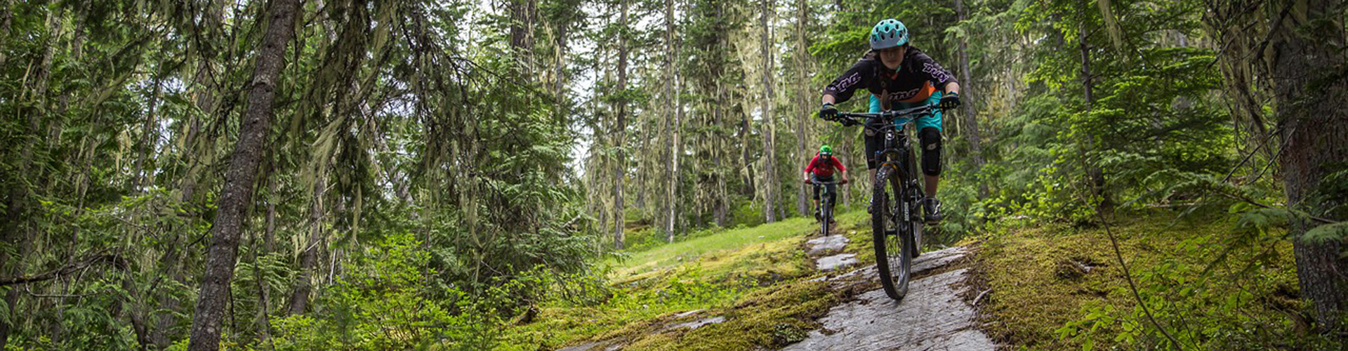 Two mountain bikers riding a steep rock slab